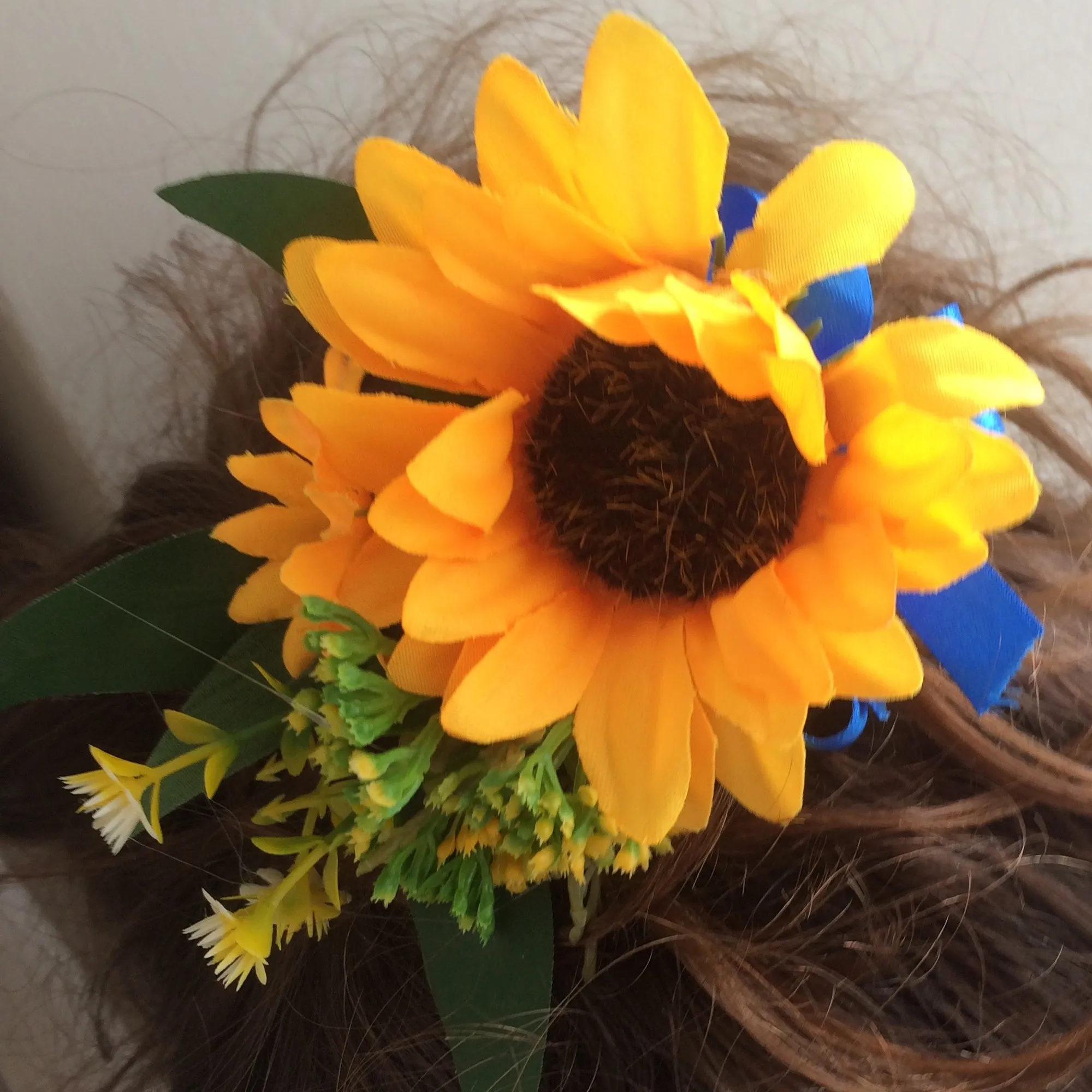 A bridal hair comb featuring yellow sunflowers & royal blue ribbon