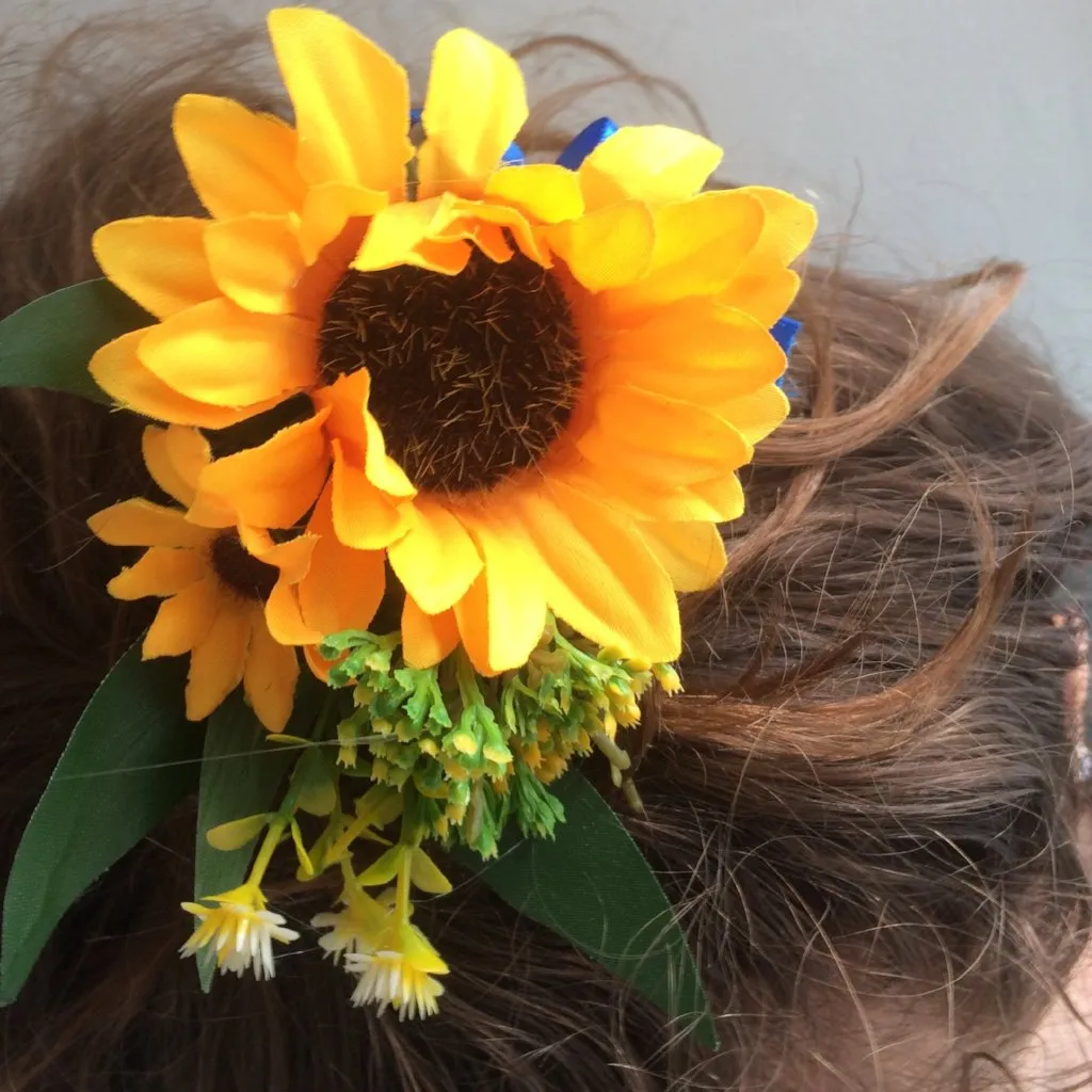 A bridal hair comb featuring yellow sunflowers & royal blue ribbon